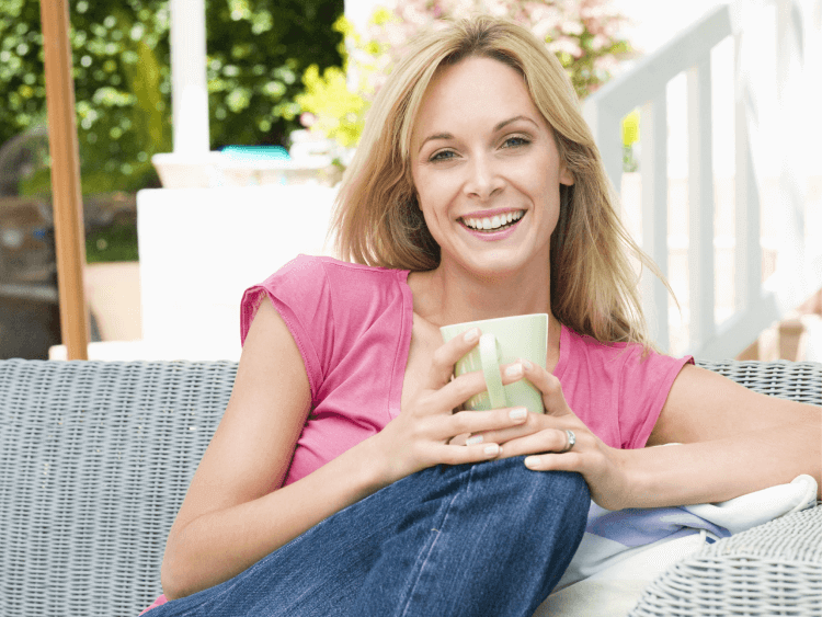 Woman sitting in patio and holding a cup